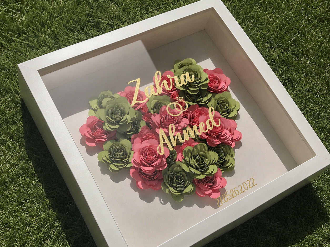 Earlier Shadow Flowers frame in pink and green paper roses with gold lettering