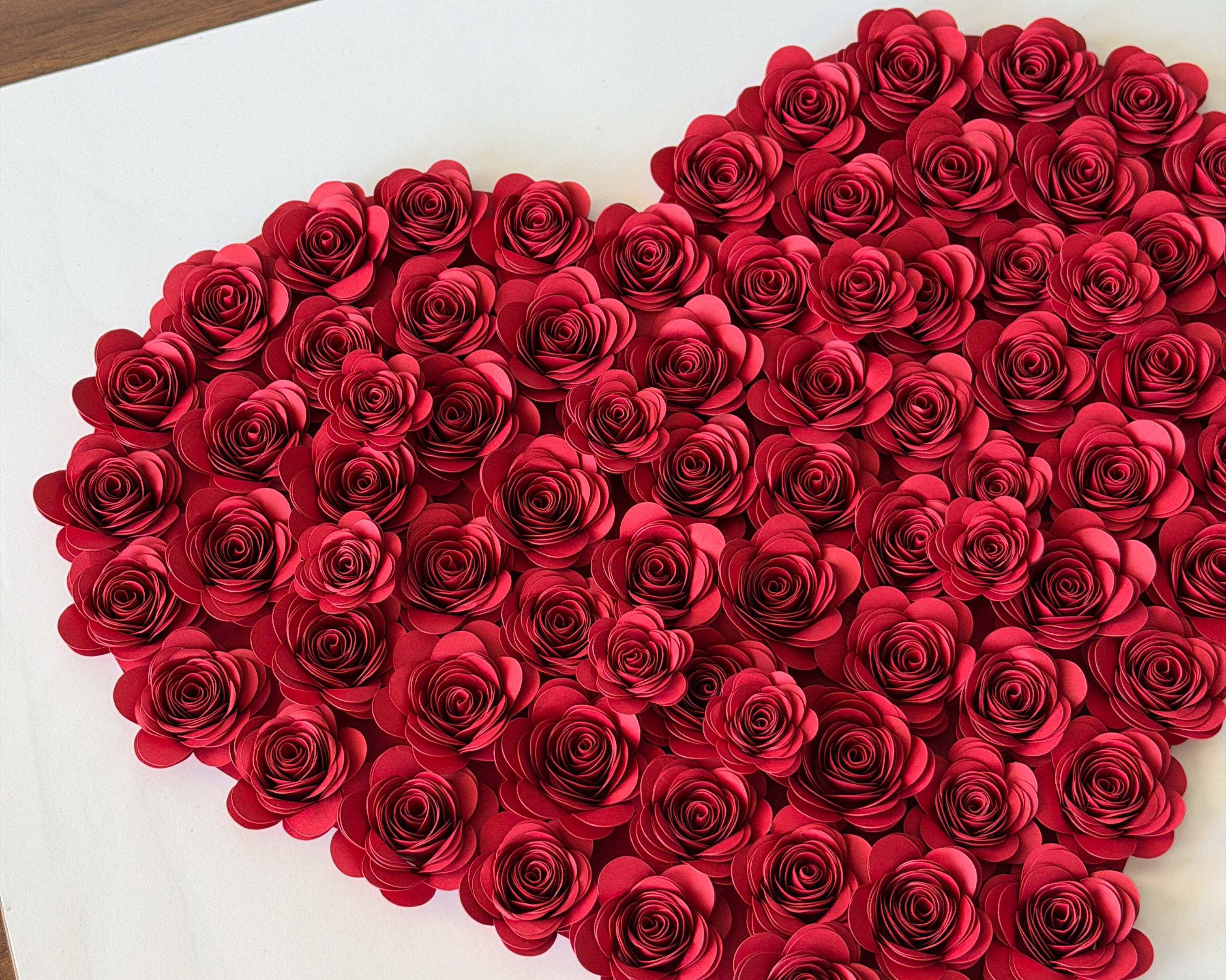 Handmade paper roses arranged into a heart before framing
