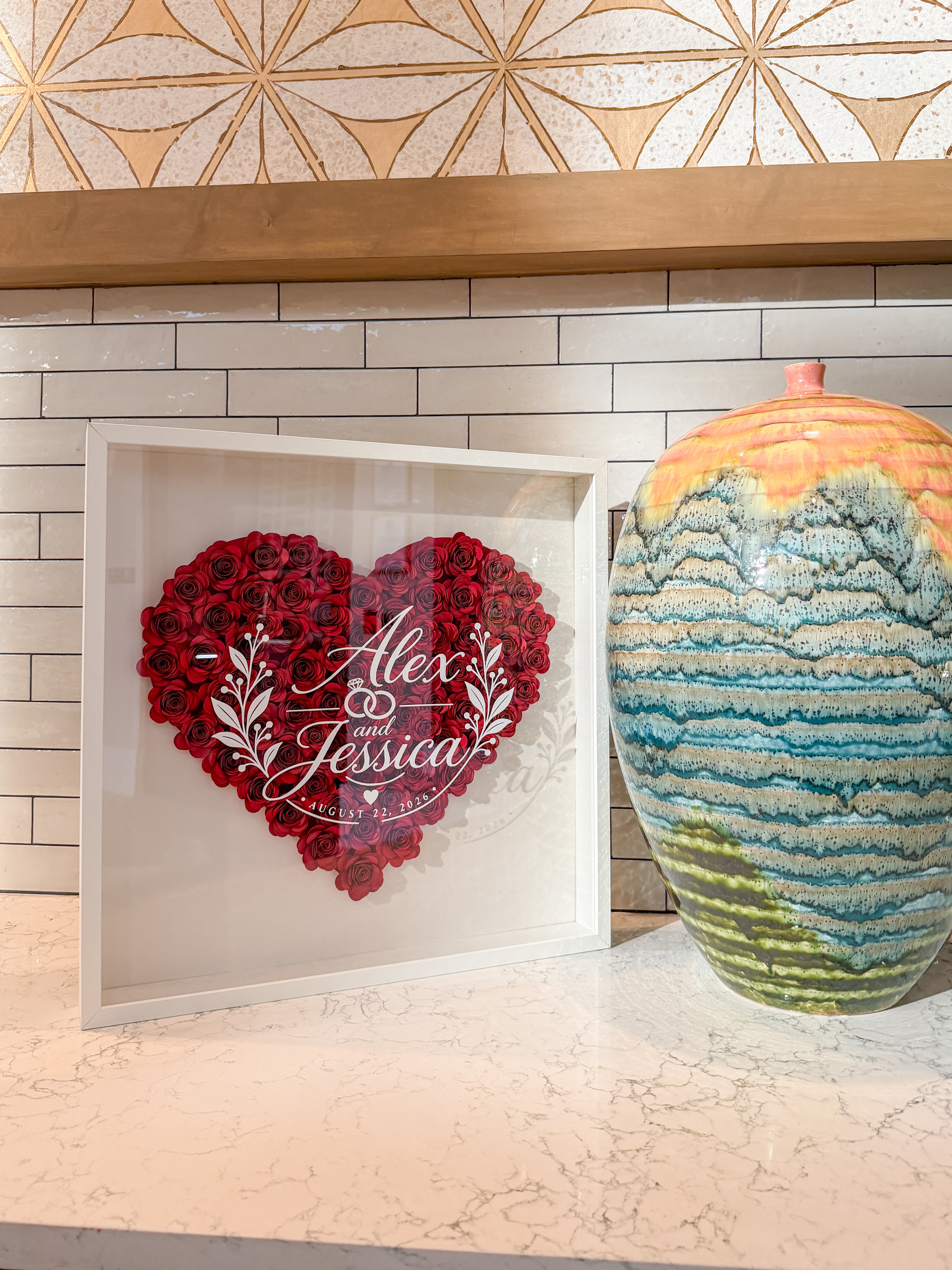 Personalized wedding flower frame with red paper roses in a heart and the couple's names on the glass