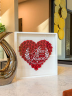 White shadow box frame of handmade paper roses styled on a kitchen counter
