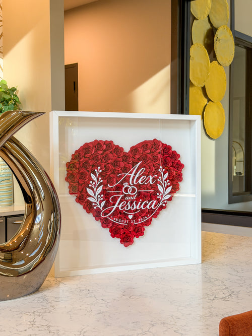 White shadow box frame of handmade paper roses styled on a kitchen counter