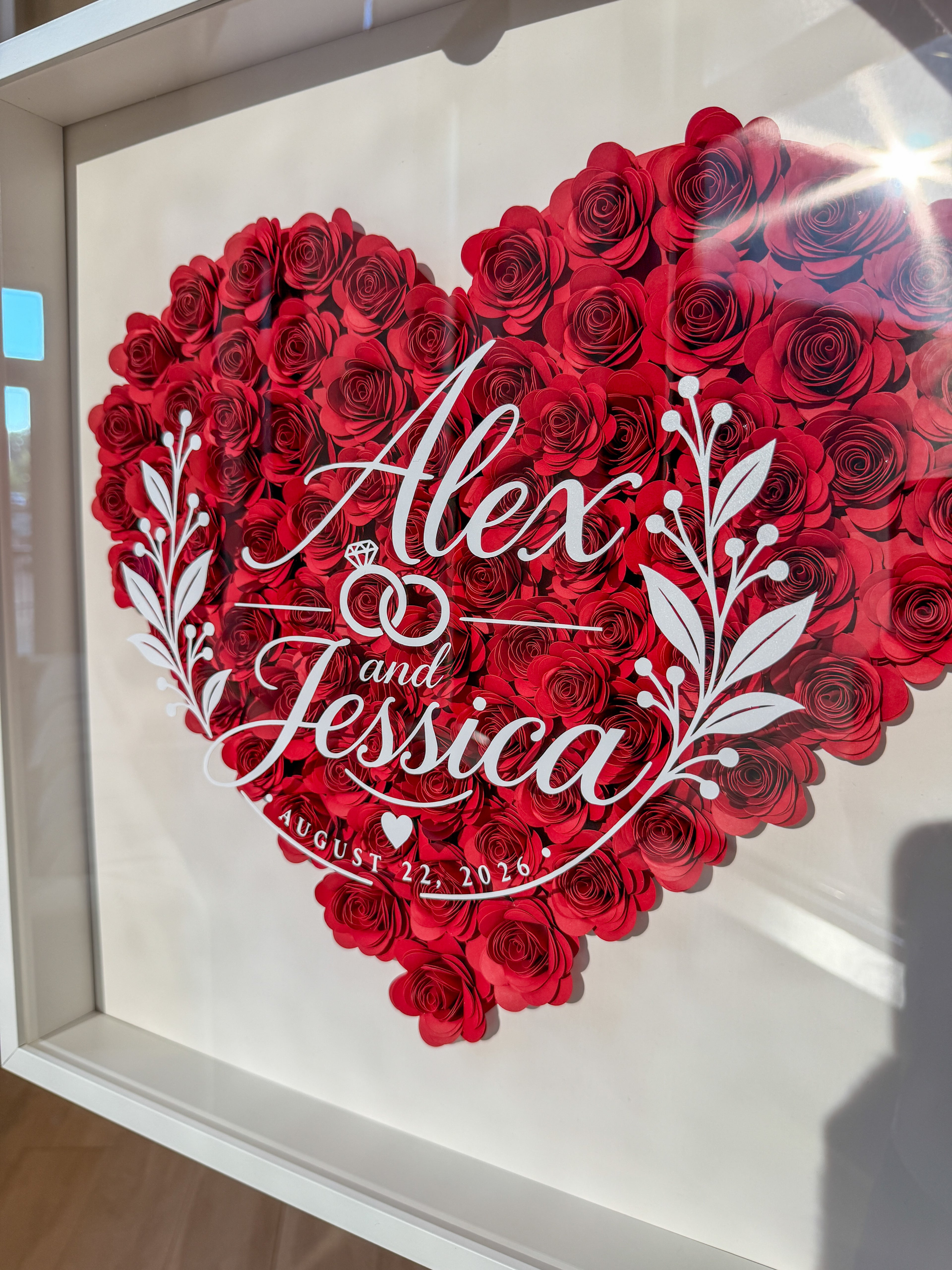 Close view of the white script lettering over a heart of red paper roses
